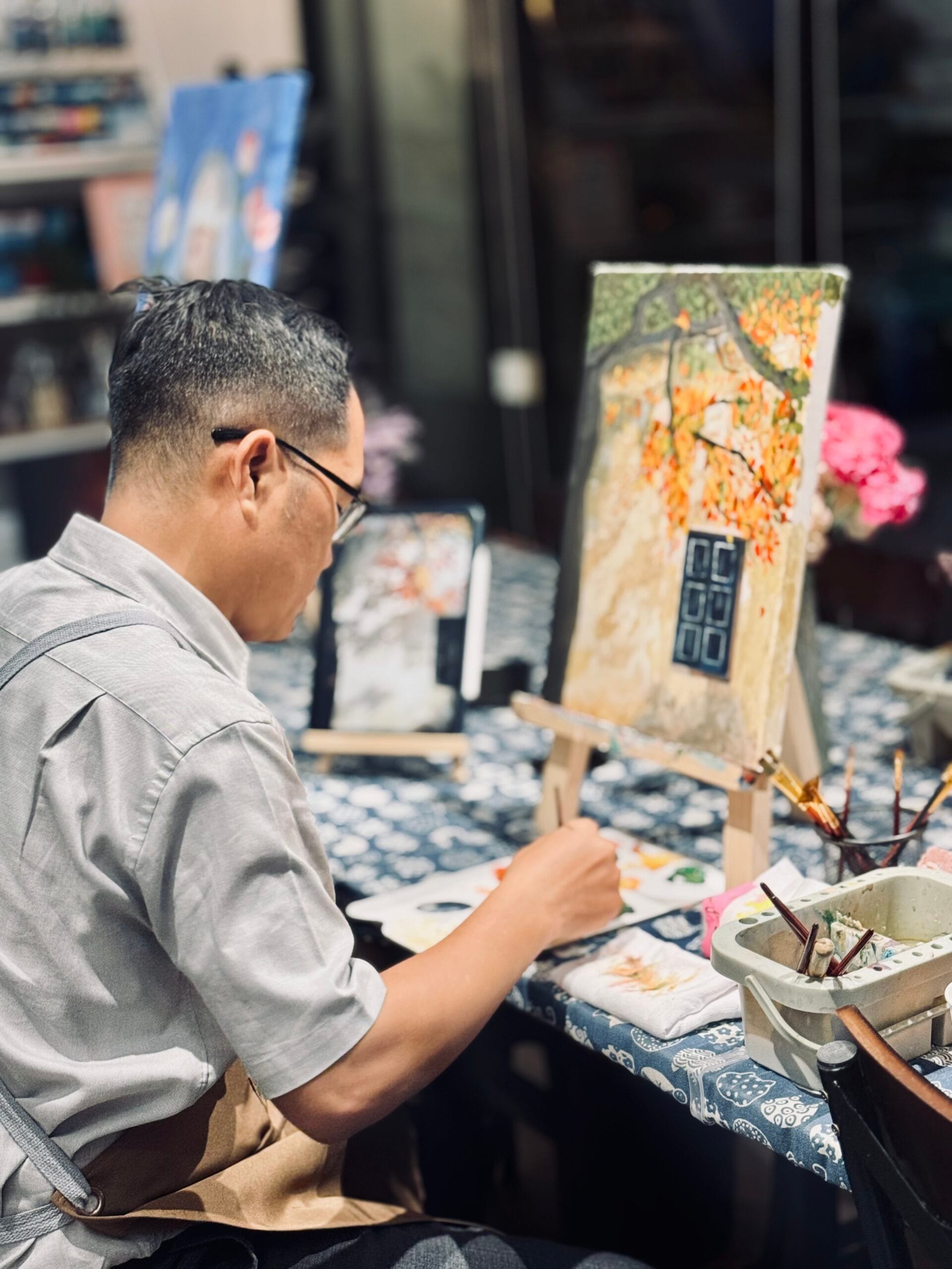 Đỗ Phương ngồi vẽ tranh xả stress bên giá vẽ trong một buổi tối