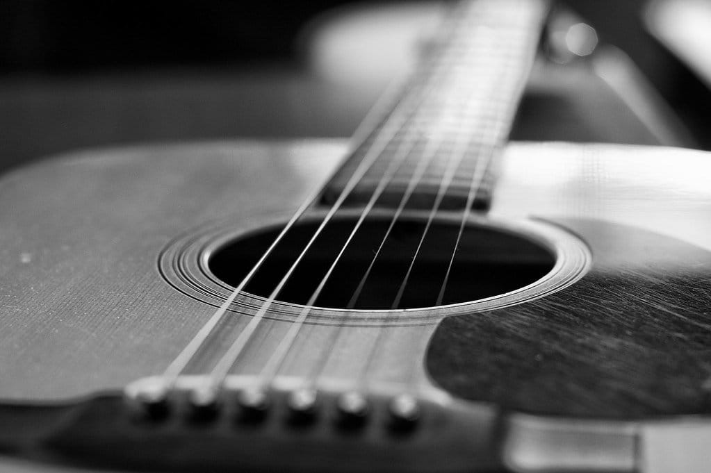 Chơi guitar thư giãn – cây đàn guitar cũ đặt cạnh cửa sổ